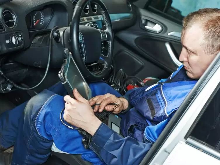 Mécanicien utilisant une valise de diagnostic électronique
